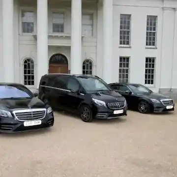 3-chauffeur-service-cars Three black chauffeur cars outside white building